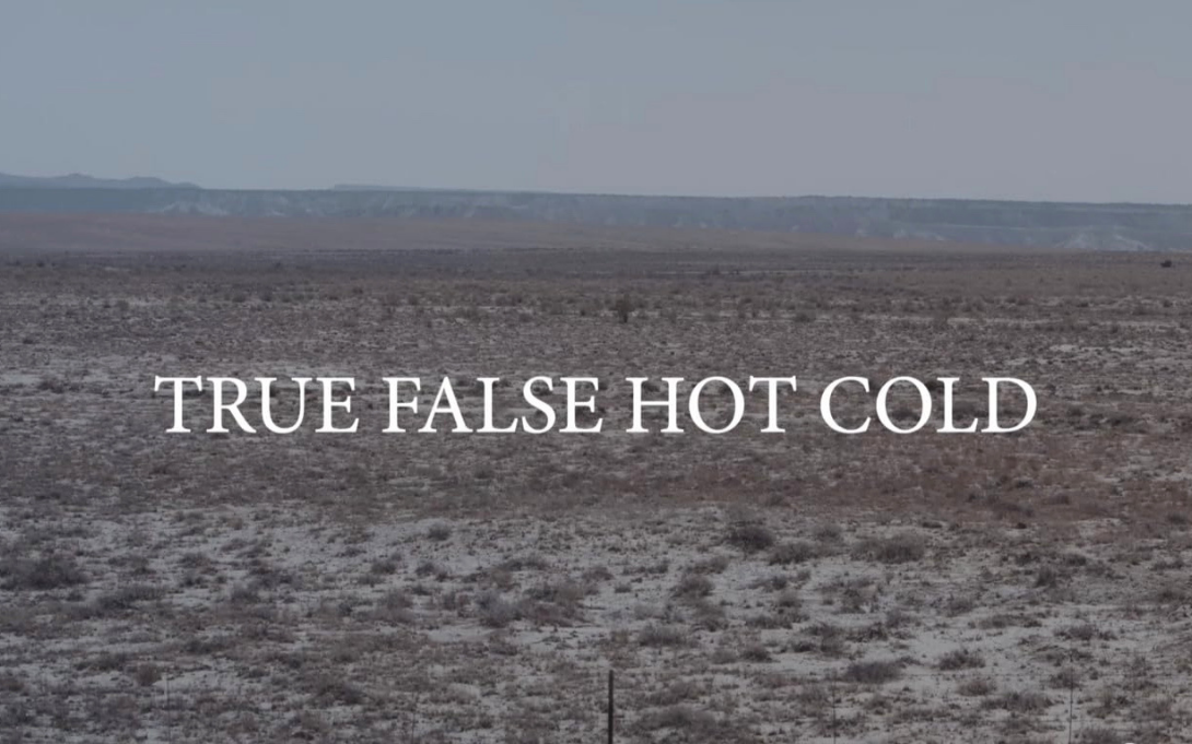 "True Fals Hot Cold" all caps white text is centered over a background image of a desert environment with mountains in the far distance