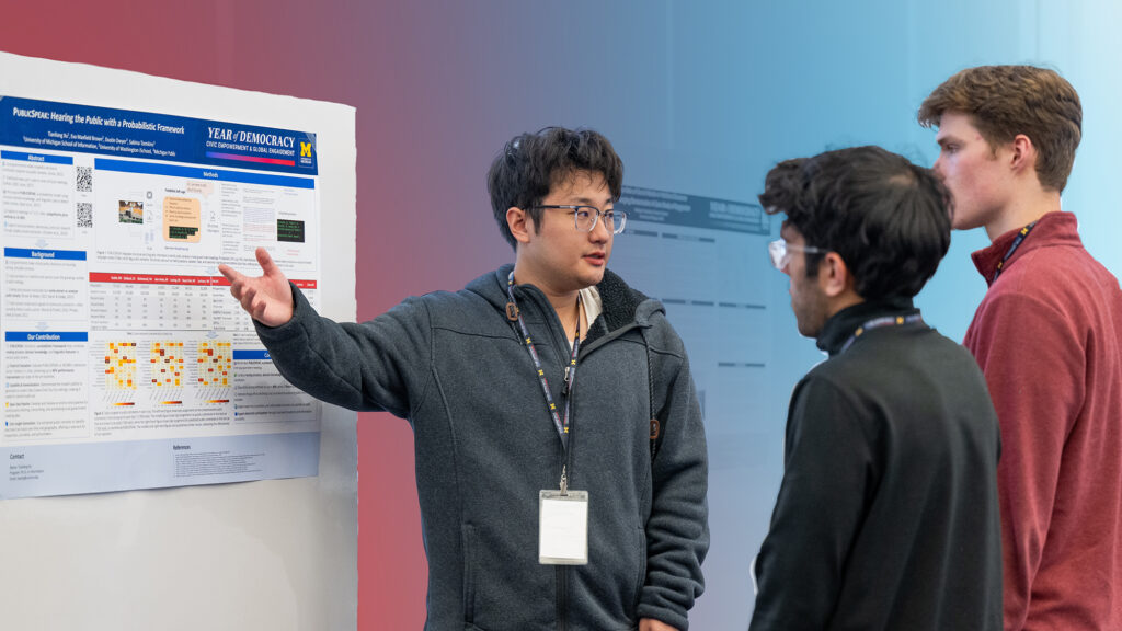 Photo of three students looking at a poster at the Year of Democracy Symposium in April 2025.